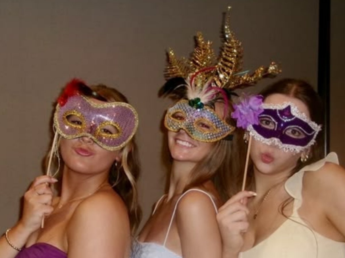 Tres amigas posando con antifaces decorados con plumas y pedrería, como los que se crean en nuestros talleres de arte